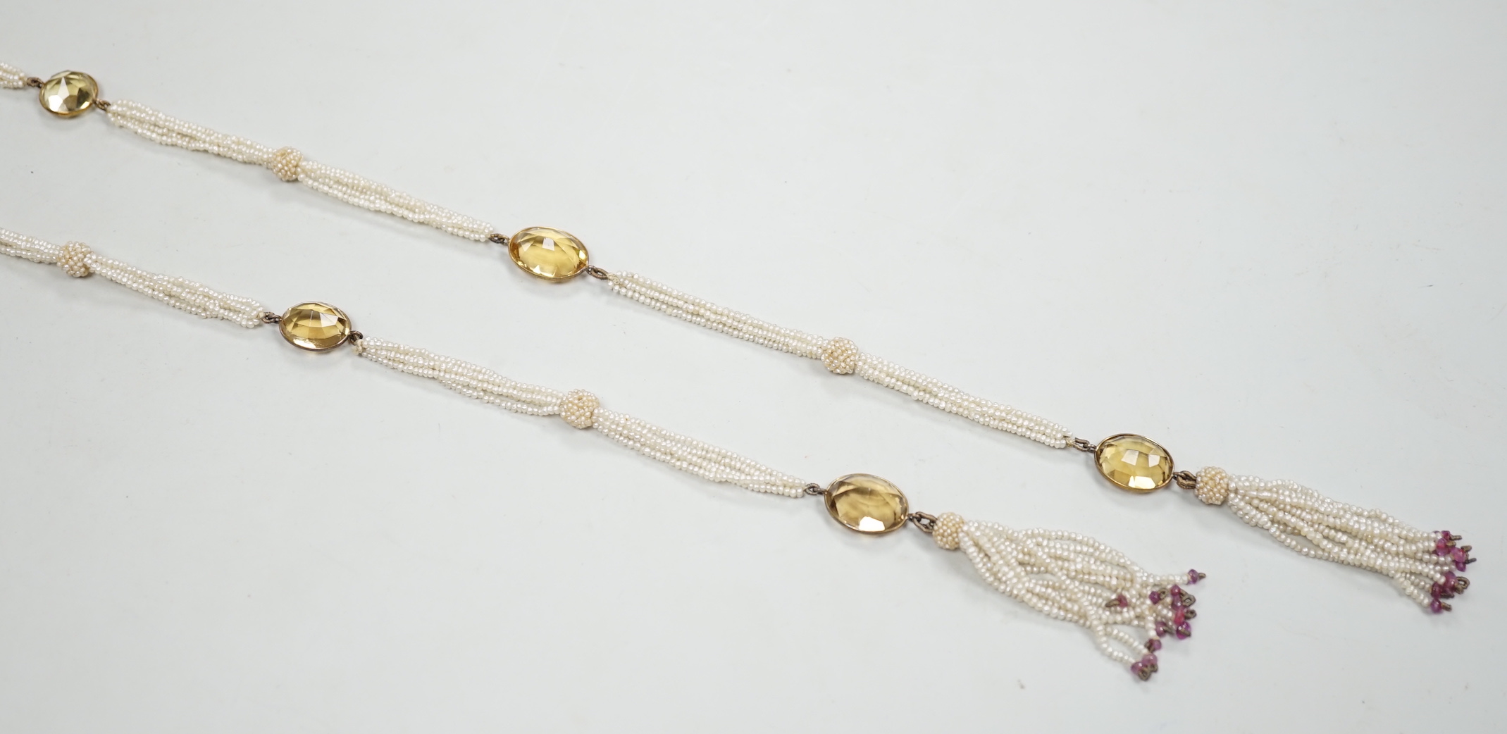 A 19th century Indian multi strand seed pearl and oval cut citrine set long necklace, with gem set tassel drops, 166cm.